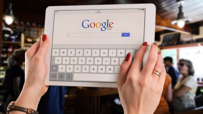 Woman holding tablet with Google homepage 