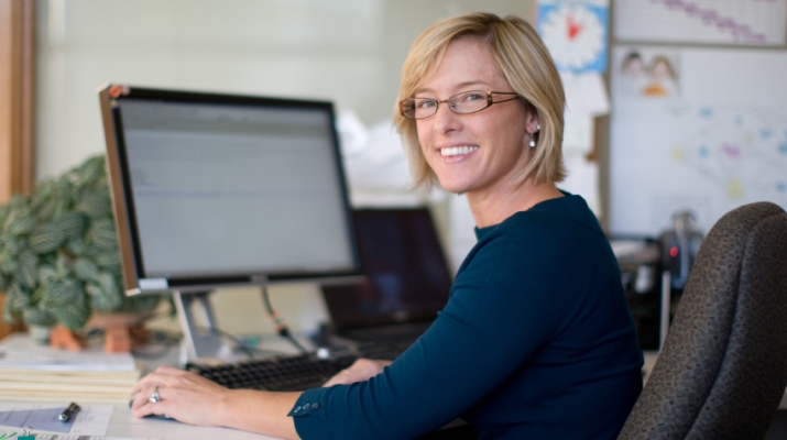 Smiling woman at computer desk