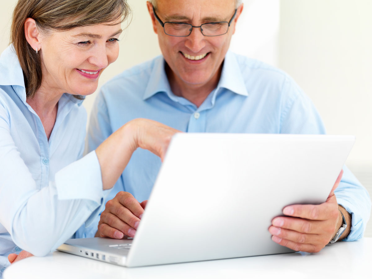 Two active adults at a laptop