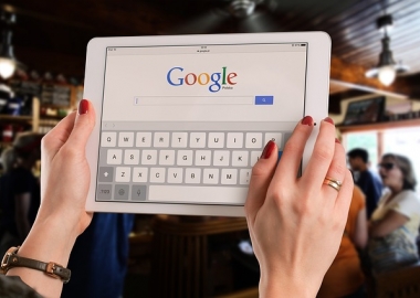 Woman holding tablet with Google homepage