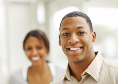 Smiling man with smiling woman in background