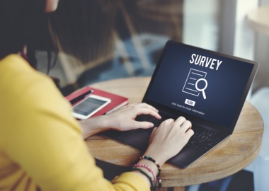 Woman with laptop that says survey
