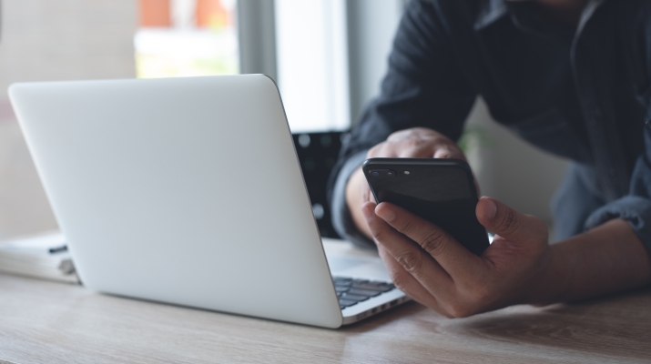 man on mobile and laptop