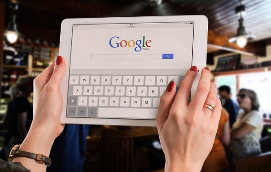 Woman holding tablet with Google homepage 