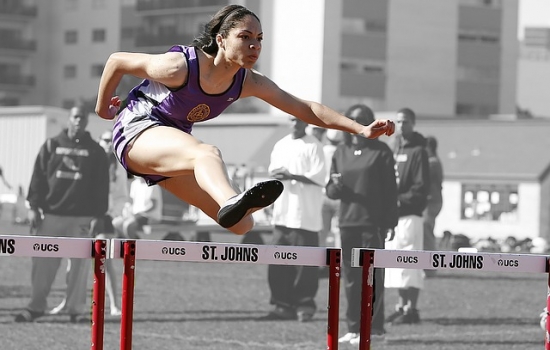 Track runner jumping hurdles