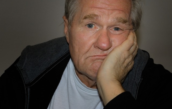 Older man with chin in his hand