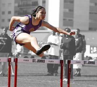 Track runner jumping hurdles 