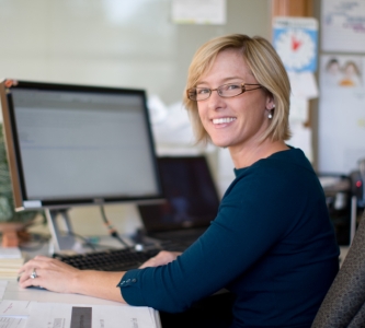 Smiling woman at computer desk