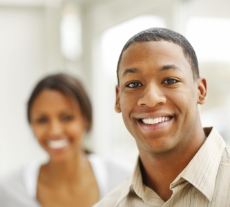 Smiling man with smiling woman in background