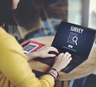 Woman with laptop that says survey