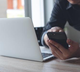 man on mobile and laptop