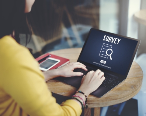 Woman with laptop that says survey