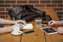 Table with coffee cub, tablet and cell phone